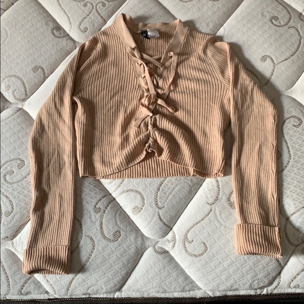 Long sleeve crop top with crosses in the front.